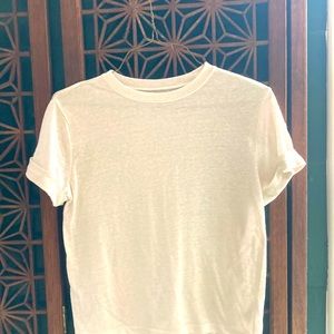 A soft white t-shirt with short sleeves that are rolled up.
